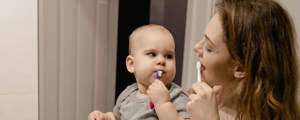 child and mom brushing together