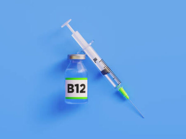 Injectable B12 vitamin and syringe on blue background, Horizontal composition with copy space. B12 vitamin concept.